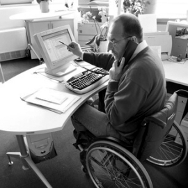 Foto von einem Mann an einem rollstuhlgerechten Broarbeitsplatz