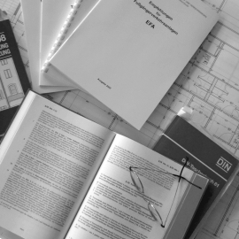 Foto von einem Plan mit Fachbchern und Gesetzestexten