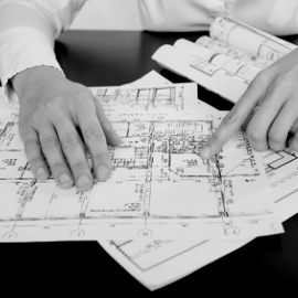 Fotoausschnitt von Hnden auf einer Planungszeichnung zeigend